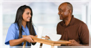 caregiver giving food to her patient